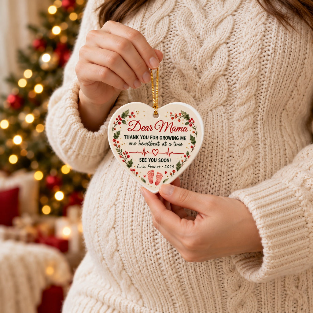 Pregnant mom holding the personalized Dear Mama heart ornament from the bump, signed Love Peanut