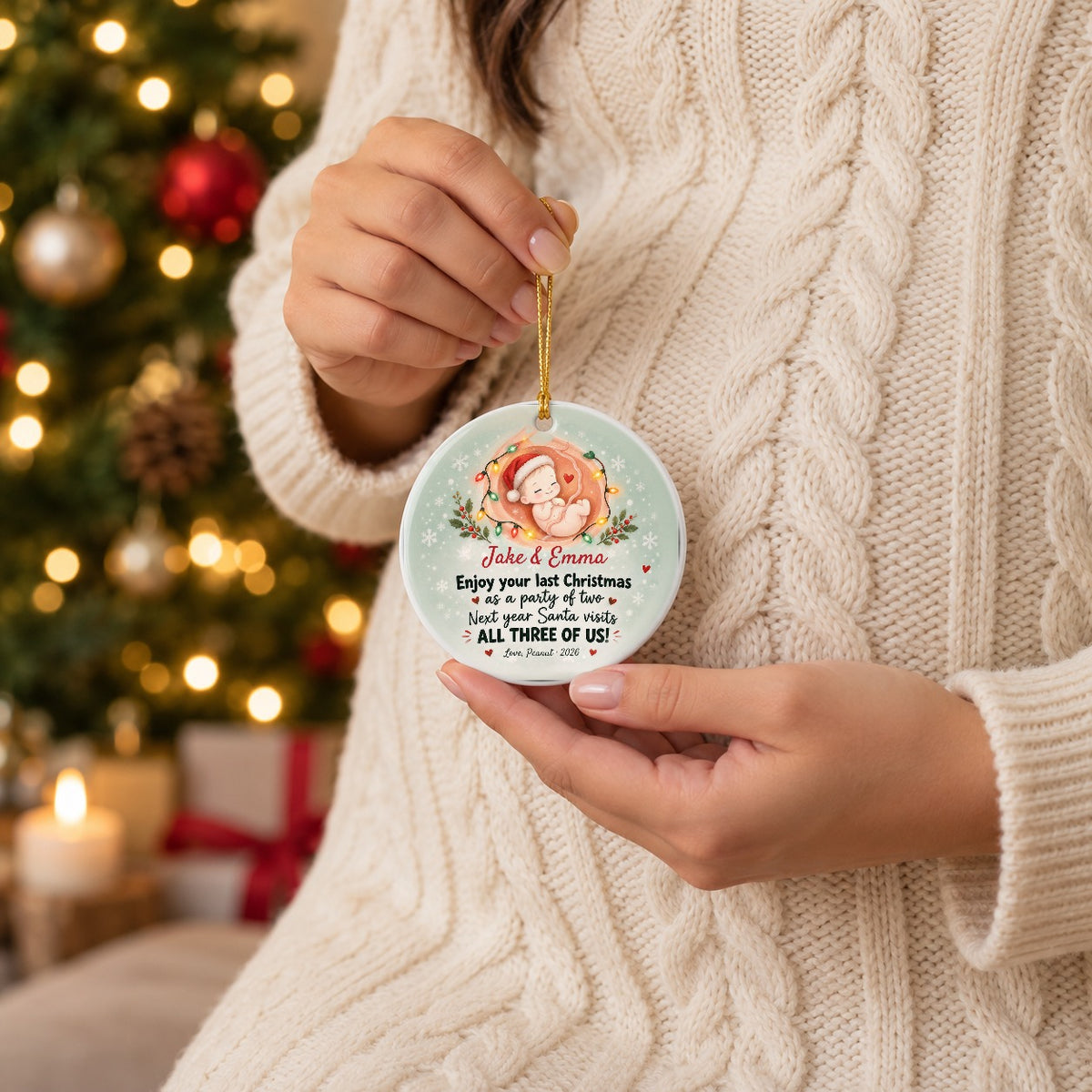 Expecting mom holding the personalized Party of Two pregnancy ornament with names Jake & Emma